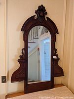 Full view of Victorian walnut dresser mirror assembly with candle shelves on each side and a carved decorative crest on top.