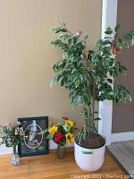 Full view of artificial tree, two floral bouquets in vases, and framed picture on floor against wall, showing the lot contents.