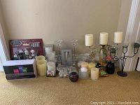 Table top display of all candles and holders included, mix of flameless and real candles, two candelabras, glass votive holders.