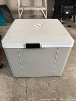 Full view of rectangular white Koolatron travel cooler closed with lid and latch secured.