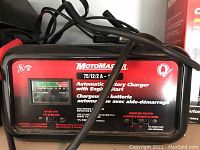 Close-up of MotoMaster battery charger front label showing model 75/12/2 A - 12 V and features.