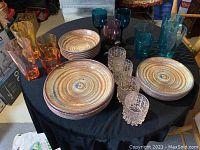 Photo of table with all plates, bowls, and assortment of colored plastic drinking glasses arranged.