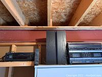 Photo showing Sony VCR, home stereo system, and pair of speakers placed on shelf.