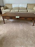 Front view of Ethan Allen wooden coffee table showing drawer pulls and classic turned legs.