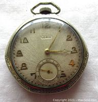 Front view of the Lorie Art Deco pocket watch showing the dial with Arabic numerals, sub-seconds dial, and overall condition including scratches on the crystal.