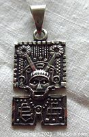 Front view of the detailed tribal-style sterling silver pendant featuring a central skull figure and ornate geometric patterns.