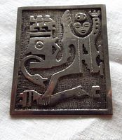 Front view of rectangular silver brooch with abstract tribal design and humanoid figure raised relief pattern