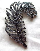 Front view of vintage silver tone leaf brooch embedded with blue stones showing intricate design and detailing.