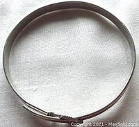 Top view of the sterling silver child’s buckle bangle, showing simple polished band with smooth interior and exterior.