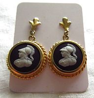 Front view of round vintage Wedgwood gold filled earrings showing white warrior profile on black background and decorative gold setting.