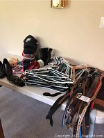 Table with assorted hats, boots, belts, and hangers