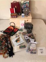 Overview photo showing multiple jewelry items, travel case, boxes, and costume jewelry including beaded necklaces, bracelets, pins and earrings.
