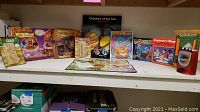 Overview of the shelf showing the Harry Potter game and puzzle, several boxed games including Candy Land, Beginner Bingo, Football game, various puzzles, and a book Children of the Sun.