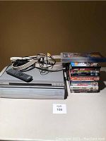 Sony CD/DVD player, media receiver, cables, remote control, and DVD movie stack on table.