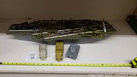 Full view of the plastic aircraft carrier with planes lined up on top and the 3 vehicles (2 cars, 1 tank) in front, showing scale and quantity.