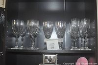 Shelf with 4 red wine glasses on left, 4 white wine glasses in center, and 4 champagne glasses on right.