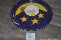 Top-down photo of the round blue and yellow chip and dip platter featuring moon and stars design