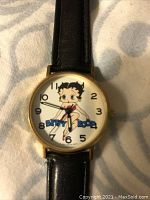 Front view of the vintage 1989 Tali Betty Boop watch showing Betty Boop character on white dial and black leather strap.
