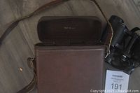 Brown leather carrying case for vintage binoculars with shoulder strap, case lid open, showing Made in USA stamp inside lid.