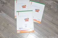 Three sealed packages of Xerox Color Inkjet Premium Glossy photo paper on wood floor.