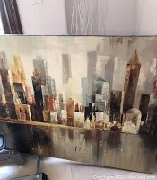 Cityscape canvas art with abstract, neutral-toned buildings and a textured painting style.