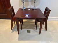 Set of kids' wooden table and two matching chairs shown from front
