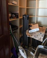 Shark upright vacuum and mop among shelving and other items