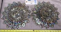 Top view of two vintage iridescent carnival glass plates showing the starburst center and pointed edge design.