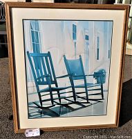 Full view of the framed art print showing the two rocking chairs on the porch with shadows and window reflections.