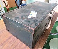 Top and side view of vintage green footlocker trunk showing metal rivets and worn paint