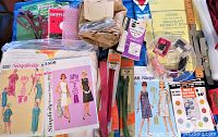 Photo showing a wide variety of vintage sewing notions including patterns, zippers, threads, fabric pieces, and embellishments
