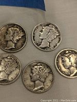 Overhead view of all five Mercury dimes showing overall condition and dates.
