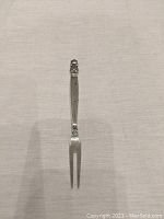 Full view of the sterling silver meat fork showing the Acorn pattern handle and two-tine fork end.