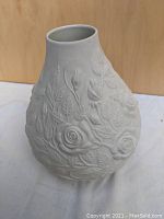 Front view of white bone china vase showing embossed floral design