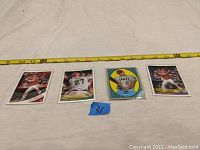 Four Mike Trout baseball cards laid flat with measuring tape for scale.