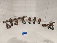 Full lot view showing all 10 painted lead soldier figurines in varied poses and uniforms on a white shelf.