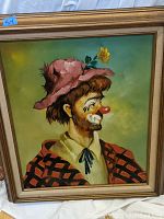 Close-up of framed clown painting on wood showing clown in pink hat with yellow flower, red nose, signed NR