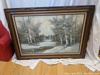 Full view of the large framed oil painting depicting a snowy landscape with river.