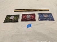 Three Liberty Head V Nickel coin collector cases lined up horizontally with a ruler above them showing scale and a small blue paper label with the number 43.