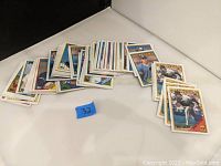Multiple vintage baseball cards spread out on white surface showing player images, names, and team logos