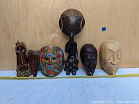 Photo of all seven masks lined up showing variety of styles, colors, and sizes, with measuring tape for scale.