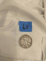 Silver Walking Liberty Half Dollar coin with the blue label '68' placed above it, showing the obverse (front) side of the coin with Lady Liberty walking and inscriptions.