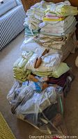 Photo showing several stacks of assorted folded bed linens, towels, and visible wooden shoe horns on top of linens.