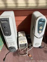 Three electric heaters: Kenwood EW7307K, small Pelonis NTK15A, and West Point WRC2605, shown side-by-side on porch.