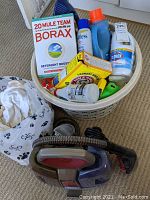 Laundry basket with Borax, detergent bottles, Clorox bleach, Arm & Hammer baking soda, cleaning cloths, and Bissell spot cleaner.