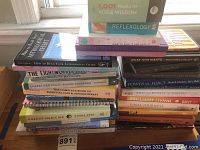 Photo showing two stacks of nonfiction and self-help books with various titles related to astrology, energy medicine, yoga, and holistic healing.