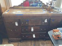 Full view of antique wooden buffet showing drawers, cabinets, decorative mirror, and gold inlay detailing.