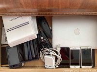 Drawer overview showing MacBook Air, charger, adapter, USB SuperDrives, cables and smartphones