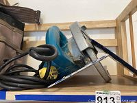 Side view of blue Makita circular saw showing cord and metal base plate.