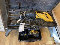 DeWalt reciprocating saw DW303M in black and yellow carrying case showing entire saw and power cord with blades in slots